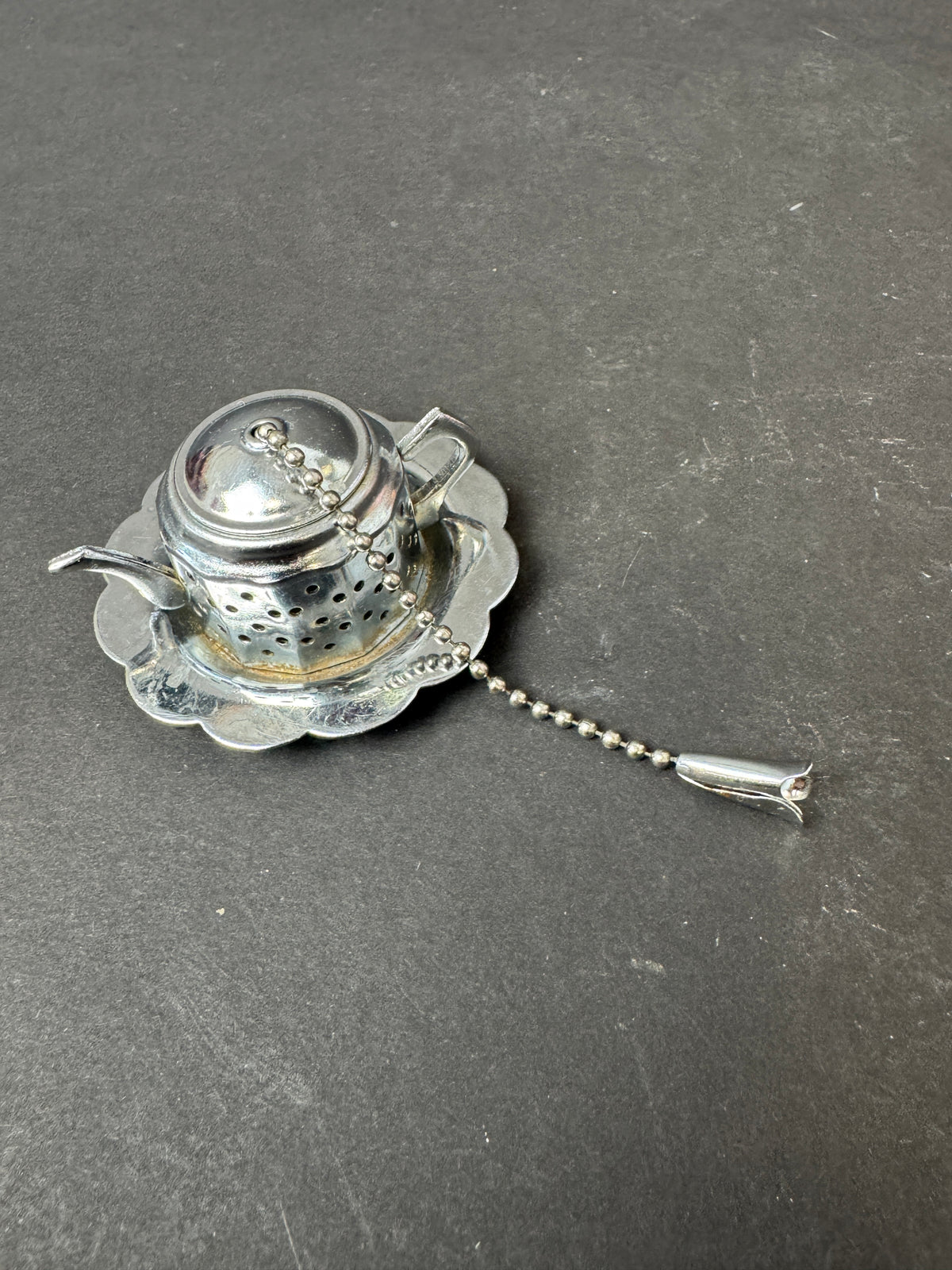 488 - Vintage Shiny Silvertone Tea Holder Strainer Teapot Shape Saucer Chain Tulip Tip